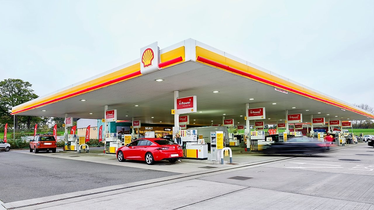 Velika Shellova bencinska črpalka z šestimi linijami za točenje goriva in na kateri stojijo vozila, ki točijo gorivo