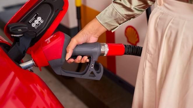 Ženska roka, ki drži Shell V-Power ročko za točenje goriva