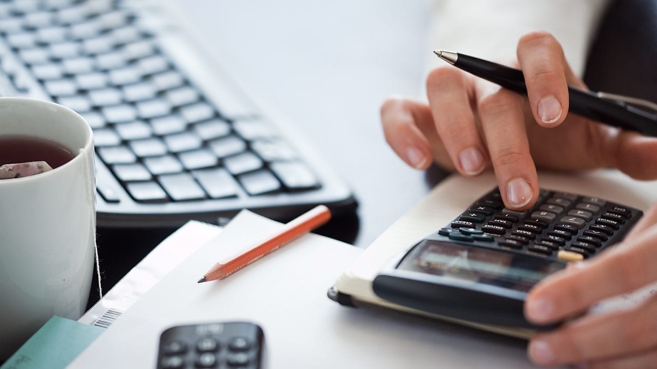 Pisarni&scaron;ki delavec uporablja kalkulator.