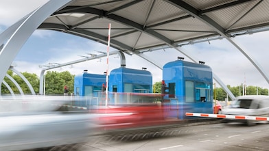 Cars travelling through toll booth at bridge