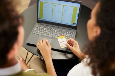 Male and Female Shell customers in an office, looking at a laptop, and discussing a Shell card.
